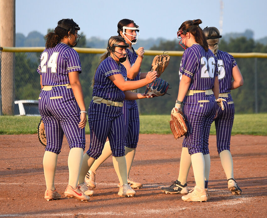 Members of the Pleasant Hill softball team break their huddle during Monday night's annual Purple and Gold Night scrimmage.