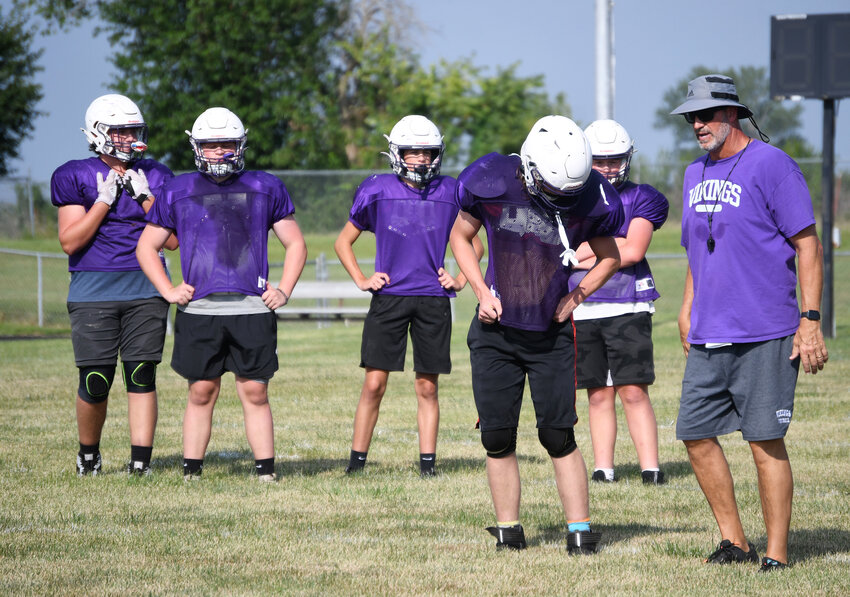 Midway coach Kyle Schenker, left, talks to his players about kickoff coverage during practice last week. The Vikings open the season at home Friday night.