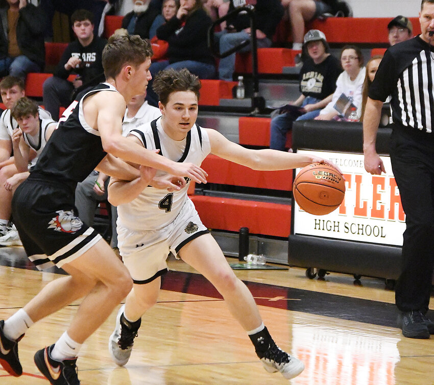 Adrian senior Cole Hamilton (4) drives around El Dorado Springs’s Aidan Rotert during Monday’s district game. Hamilton scored 14 points in the Blackhawks’ 55-44 victory.