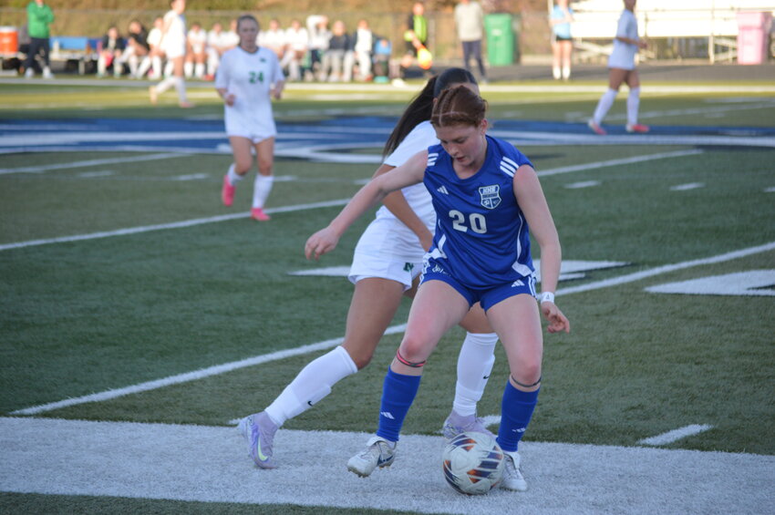 Harrisonville’s Rylie Ingrassia (20) uses her body to shield a St. Michael player from the ball during the Wildcats home game last week. Harrisonville lost 2-1.