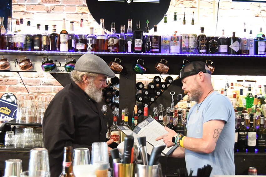 The District chef Douglas Geyer, left, talks to daytime bartender Aaron “Buff’ Norman after a lunch rush last Thursday. Geyer has brought his decades of chef experience to the Harrisonville square restaurant, while also trying to live up to his family’s legacy in the community.