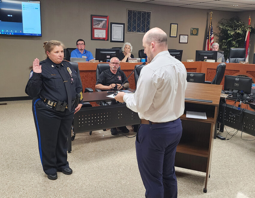 Harrisonville Police Chief Darla Harris, left, is sworn in by City Clerk Daniel Barnett during Monday’s board of aldermen meeting. Harris served as interim police chief last year after former Chief John Hofer retired.