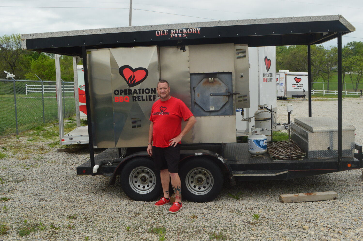 Stan Hays, CEO and co-founder of Operation BBQ Relief, began his Peculiar-based organization in 2011 to help victims after an EF-5 tornado ripped through Joplin. Here, he stands by the original trailer and smoker used in Joplin. The group has delivered over 13 million meals across the U.S. during the past 14 years.