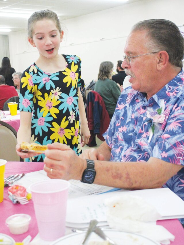 Ivan Koop receives his dessert from his granddaughter Macy Boone, Sublette. Boone volunteered to serve at the dinner.