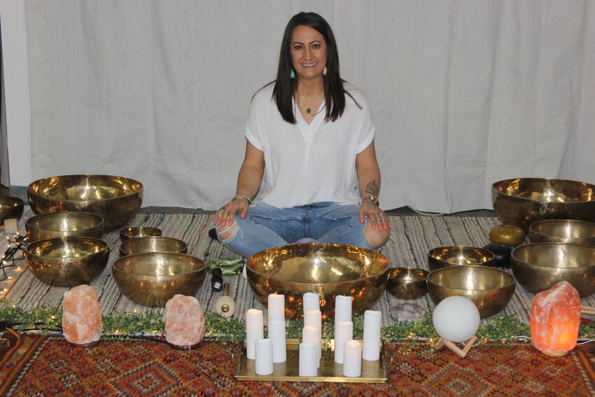 Flor Field sits with her tools utilized for sound bath meditation for clients wanting to have their energy renewed.