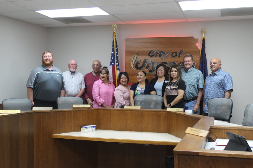 Photo Left: Lucy Watie and her group of Promotoras gathered for a picture with City Council members during a recent regular meeting of the council. (Left to right): Caleb Woods, Sam Guy, John Duran, Josephina Pando, AngieLee Esquivel, Laura Santos, Lucy Watie, Marisela Aguilar, Tim McCauley, and Terry Maas. Photo right: Lucy Watie spoke at the Chamber Coffee May 26 to inform the public about her work with Immunize Kansas Coalition.