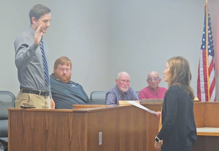 Ulysses City Clerk Sarah Britton, far right, swears in new City Administrator Luke Grimes during a recent city council meeting as council members look on.