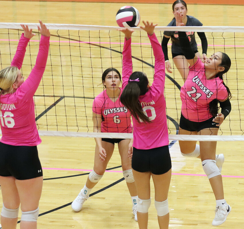 Ulysses sophomore Devany Vitolas (21) knocks the ball over the net during set two against Hugoton, Thursday night. Defending for Hugoton are Ana Cruz (16) and Emily Tinoco (10). The Lady Tigers swept the Eagles 25-15, 25-18.