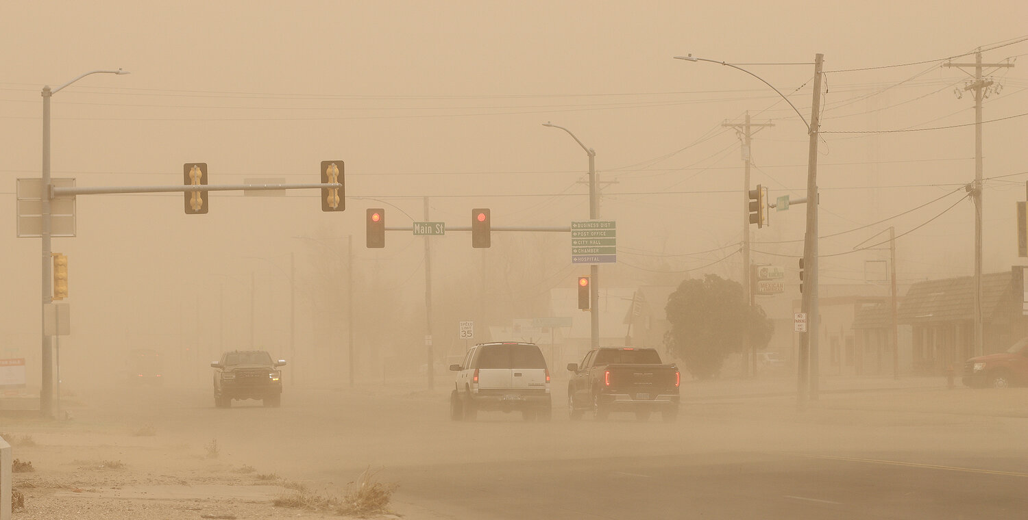 Drivers navigate the intersection of Main and Oklahoma on Friday in Ulysses. In Grant County, winds March 14 gusted to 73 mph and kicked up a wall of dirt reminiscent of the 1930s dust bowl and reduced visibility to less than a quarter mile on area highways.