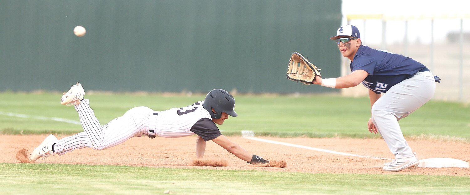 Roman Romero dives back to first base for Ulysses against Scott City April 1.