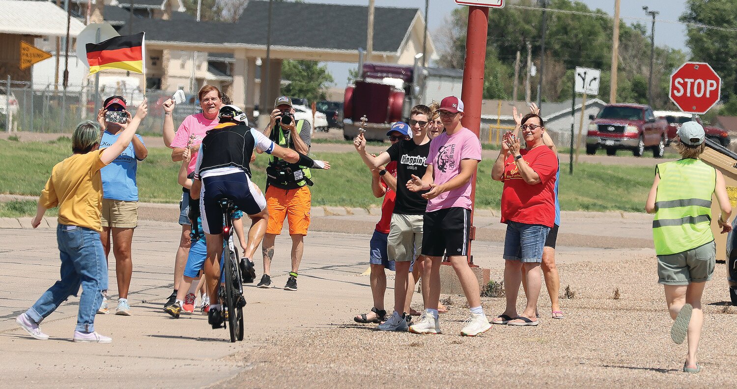 (Above photo) Volunteers, racing fans and crew members greet German rider Claus-Henning Schulke during the Race Across America June 15, 2024 in Ulysses. Racers from across the planet will be competing in the Race Across America from California to New Jersey. Ulysses is Time Station #23 and racers are expected to begin arriving for the 2025 race on June 13 and will be coming through town through June 18.