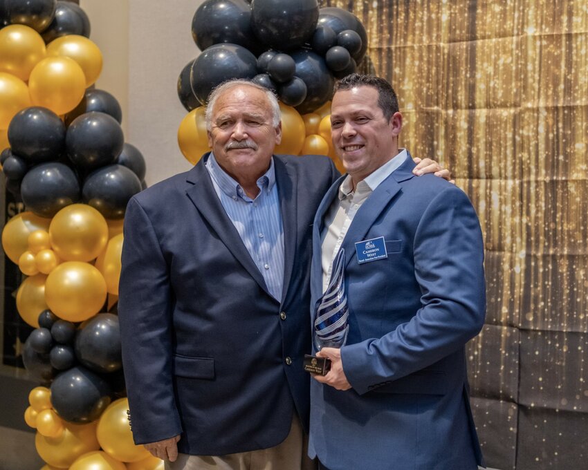 Cameron West (right) stands alongside his father and mentor, Mike West (left), celebrating Cameron's recent accolade as Realtor of the Year, a moment of pride and testament to their professional legacy in the real estate industry.