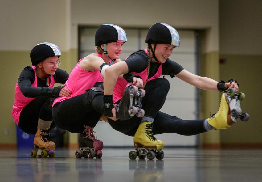 From left to right, Napiqua Gibbs, Paige Runions and Alice Farrell practice a roller skating train.