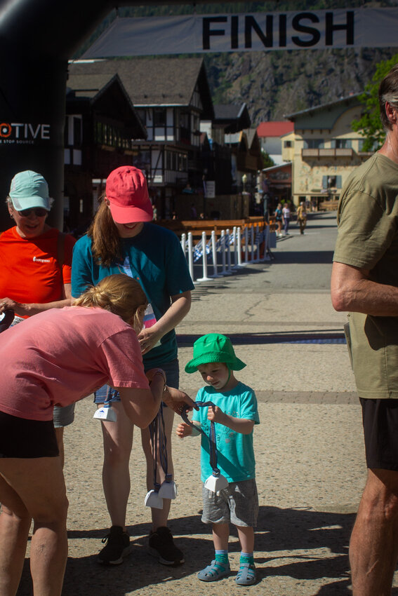 A young participant receives his cowbell at the finish line.