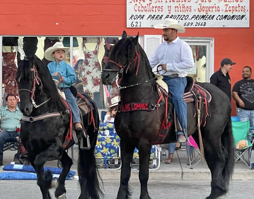 He’s filling the boots, and soon, nine-year-old Juan Pio, shown here riding with his father, Luis, will fill the saddle as he performs on his dancing mount during the festivities.