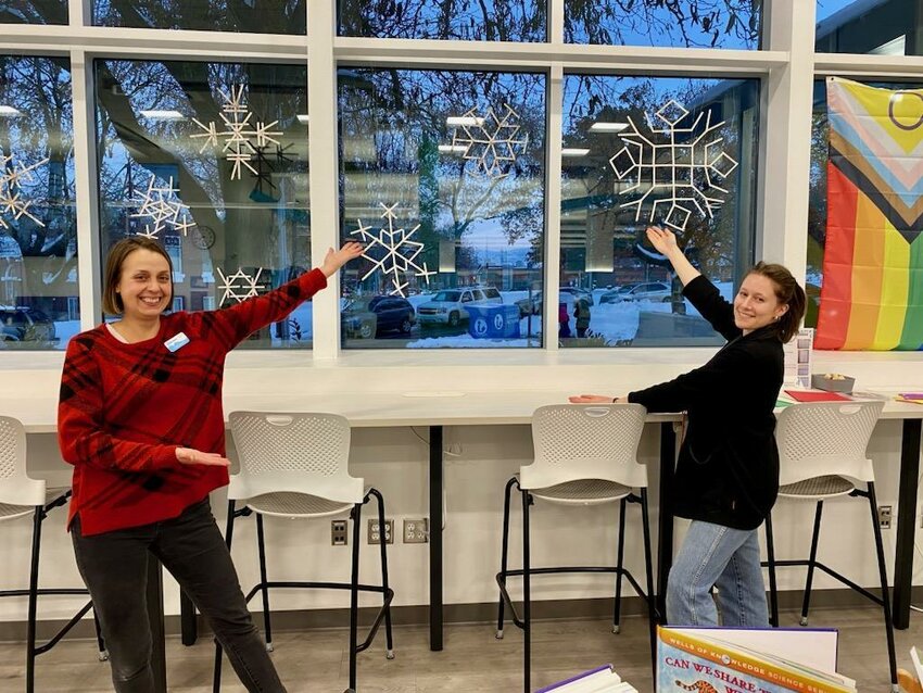 Wenatchee Public Library employees Chelsea Evans and Molly Schuringa display snowflakes, made from popsicle sticks by youth at the Chelan County Juvenile Detention Center.