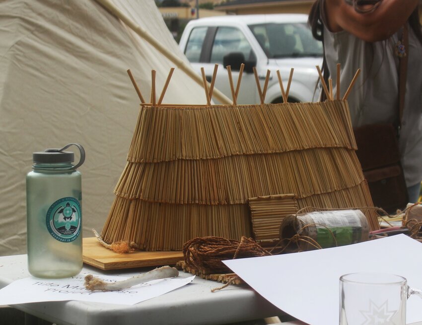 A miniature model of the tule mat lodge provides a visual scale of what the finished structure will appear.