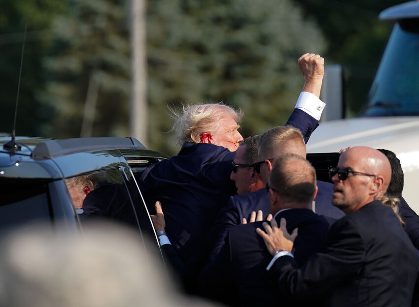 Secret Service agents assist former president Donald Trump into a vehicle after a campaign rally Saturday in Butler, Pa.