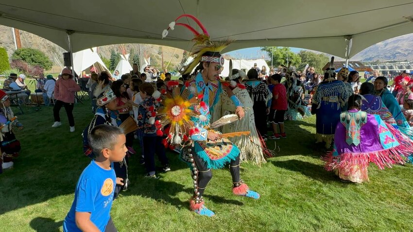 A colorfully dressed Native American dancer performs at a previous Wenatchee River Salmon Festival, captivating young attendees. The upcoming festival on Sept. 21 will feature 43 Native American educators and exhibitors, offering visitors an immersive cultural experience as part of the event's educational programming.