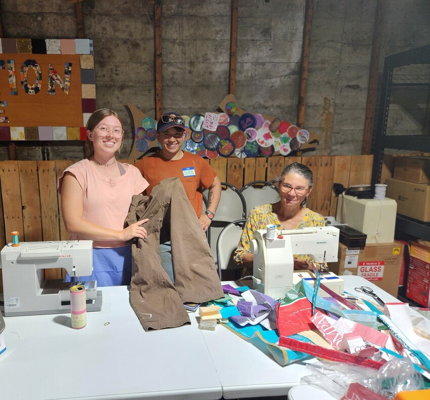 Fixers Amy Massey (right) and Virginia White (left) pose with their satisfied customer, Beryl, and her repaired pants.