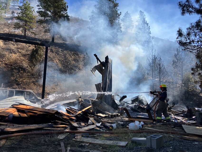 Cascade alum Juan Castro Cervantes helps put out the remaining fire on his former teachers’ home.