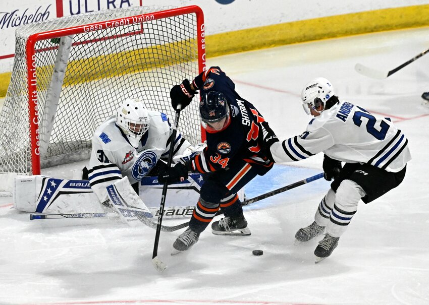 Wenatchee Wild defenseman Reid Andresen (right, 21) pushes Kamloops Blazers forward Oren Shtrom (center) away from the puck in Sunday’s Western Hockey League game at Town Toyota Center. Andresen had an assist as the Wild took a 2-1 overtime defeat against Kamloops.