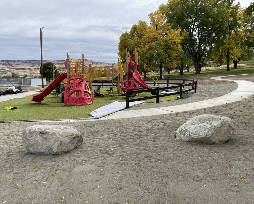 Workmen confer at the new sports court under installation in Berryman Park.