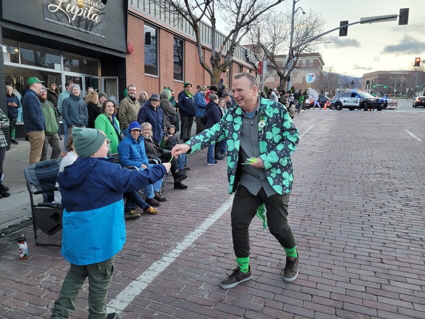 Wenatchee Mayor Mike Poirier hands out glow sticks to kids in the parade crowd.