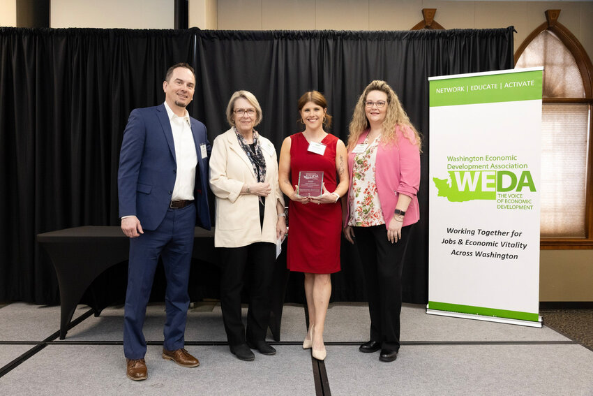 Brooke Lammert (in red), Economic Development Specialist at the Chelan Douglas Regional Port Authority, accepts the 2025 WEDA Innovation in Economic Development Award for the Trades District Project at the organization's Winter/Spring Conference in Olympia on March 26. The award recognizes the Port Authority's pioneering approach to cultivating business growth and entrepreneurship.