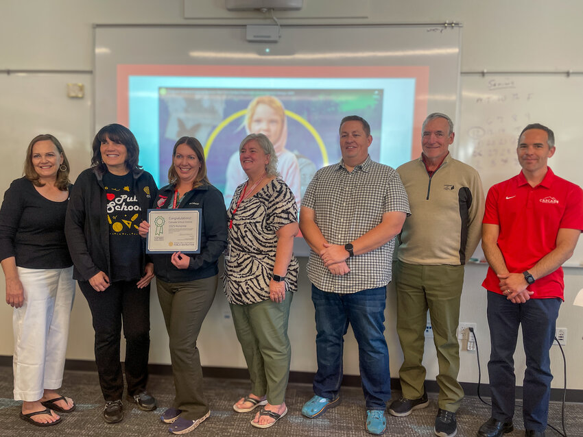 Cascade School Board poses with the Green Ribbon award alongside OSPI representative Denise Davis.