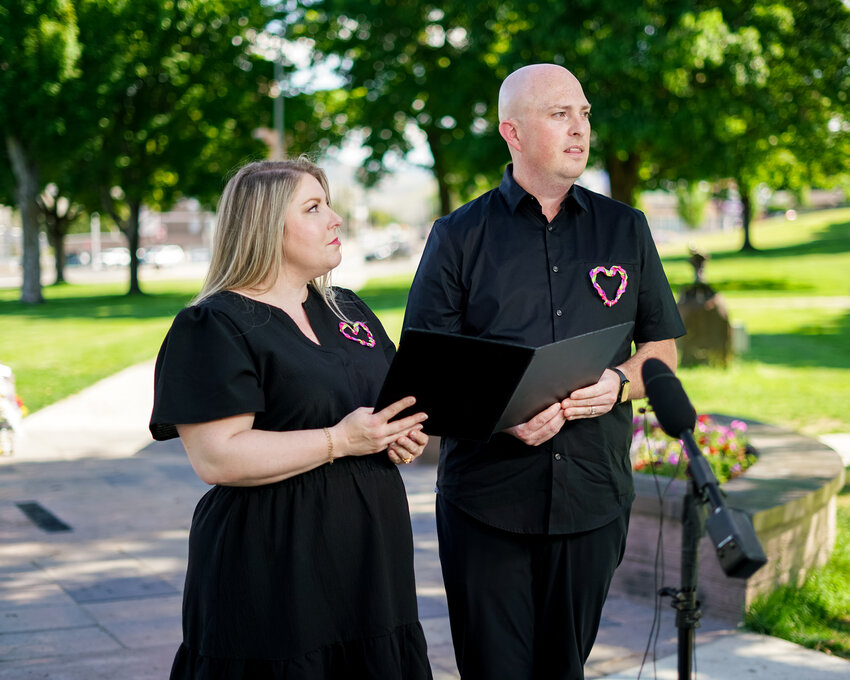 Amy Edwards and Mark Belton pay their respects at the memorial site where a vigil was held for the Decker sisters just days ago.
