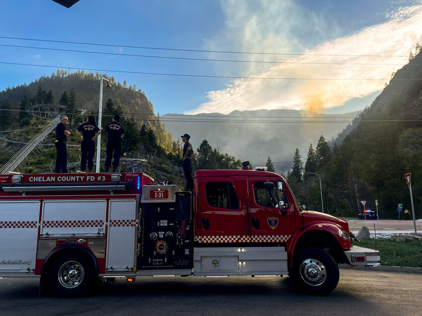 Firefighters stand by as Chelan County Fire District 3 responds to a brush fire near milepost 98 on Highway 2.