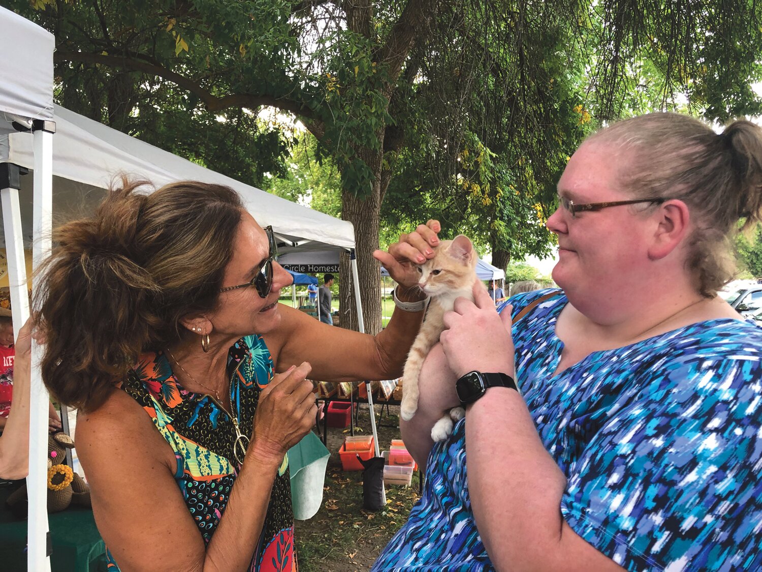 Dena Ramirez-Halle of Wenatchee (left), and Sara Nagel of Whidbey Island (right) hold Buffy (Buff), one of the kittens being taken care of by April Leaf of Chelan Valley Feral Cat Project, at the Chelan Farmers Market on September 7.
KATIE LINDERT/WARD MEDIA