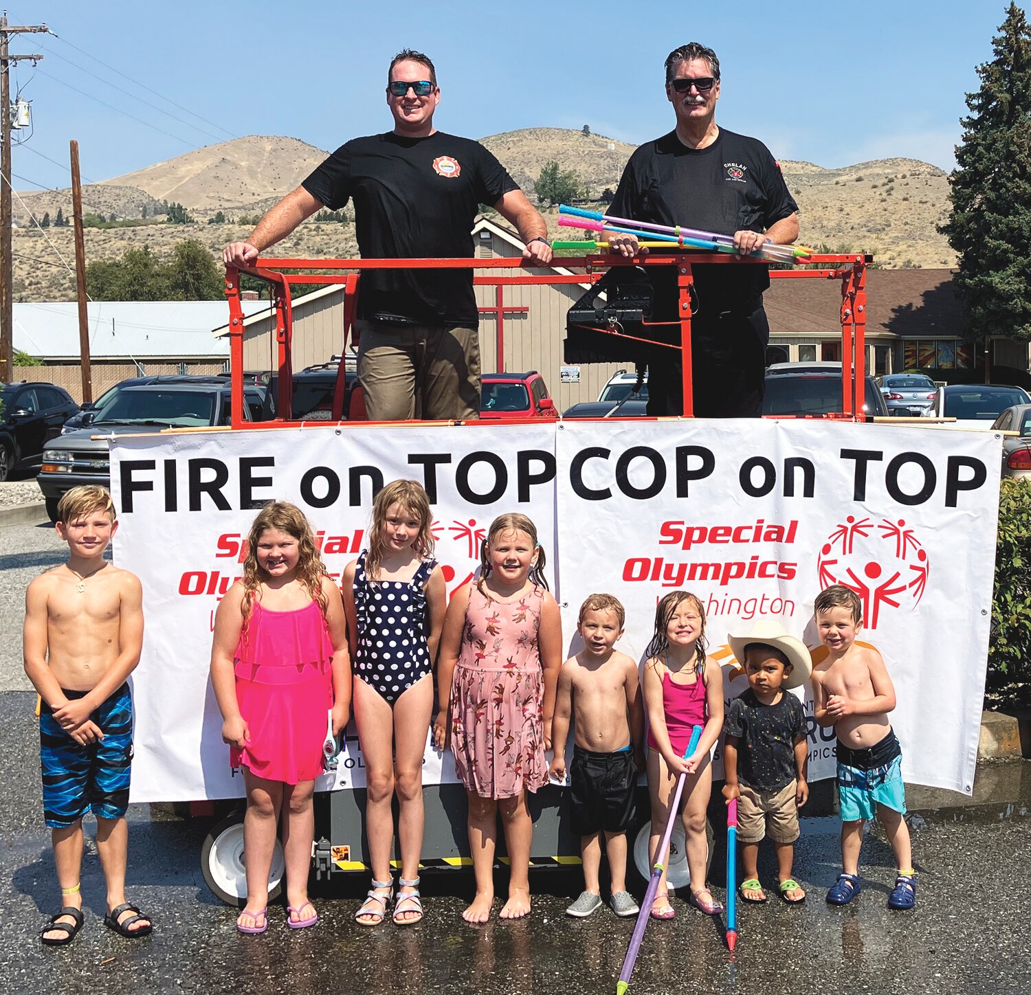 Five hundred gallons of water were used during the Fire & Cop on Top event on August 4, with around 100 participants taking aim at Chelan Fire & Rescue and Chelan County Sheriff personnel. Pictured with some of the children are Troy Keene, (left), and Dennis Hill (right of Chelan Fire & Rescue.
Courtesy Regional Manager Tim Toons