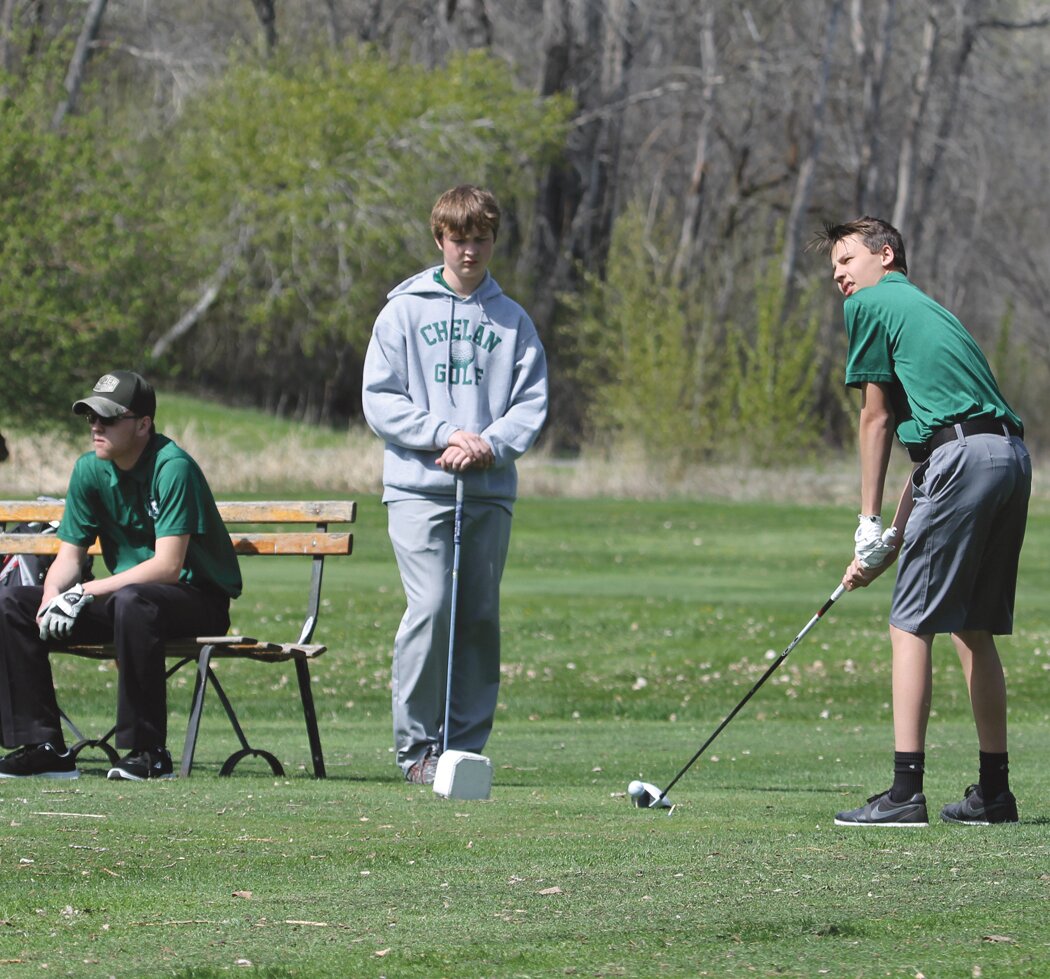 Goats Golfers (left to right) Jeremy Avery, and Connor Abel wait as teammate Ainsley Pehrson lines up his shot, Tuesday, April 24 at Omak.