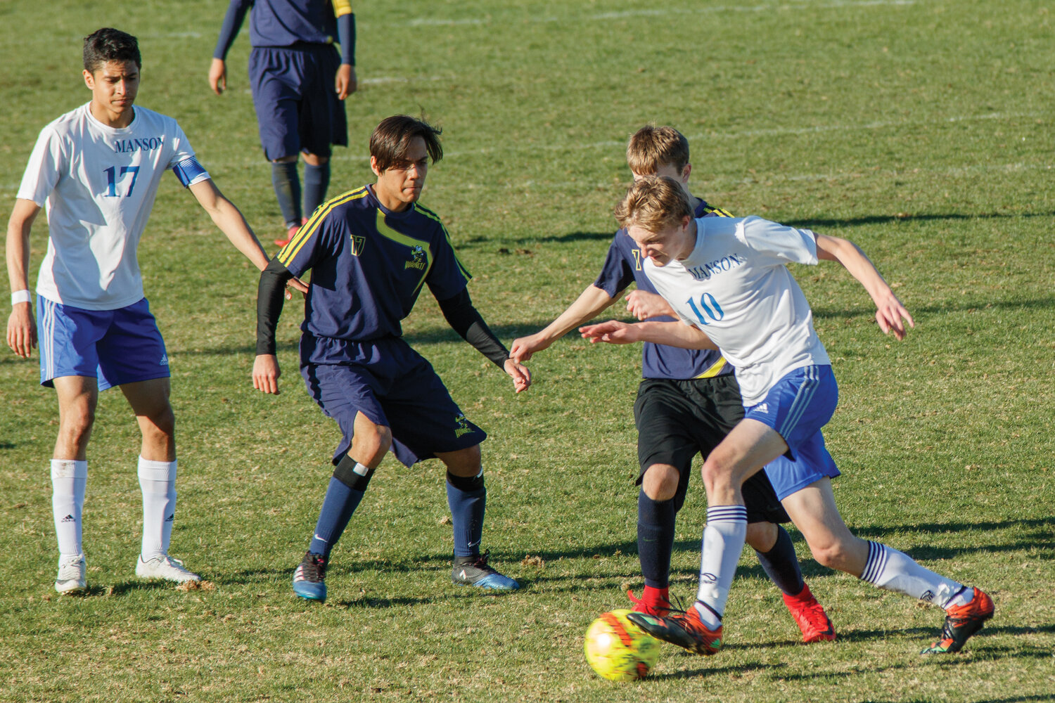 Oliver Ellingson (front right) battles to keep possession of the ball, with Team Captain Eduardo Escalera (far left) assisting.