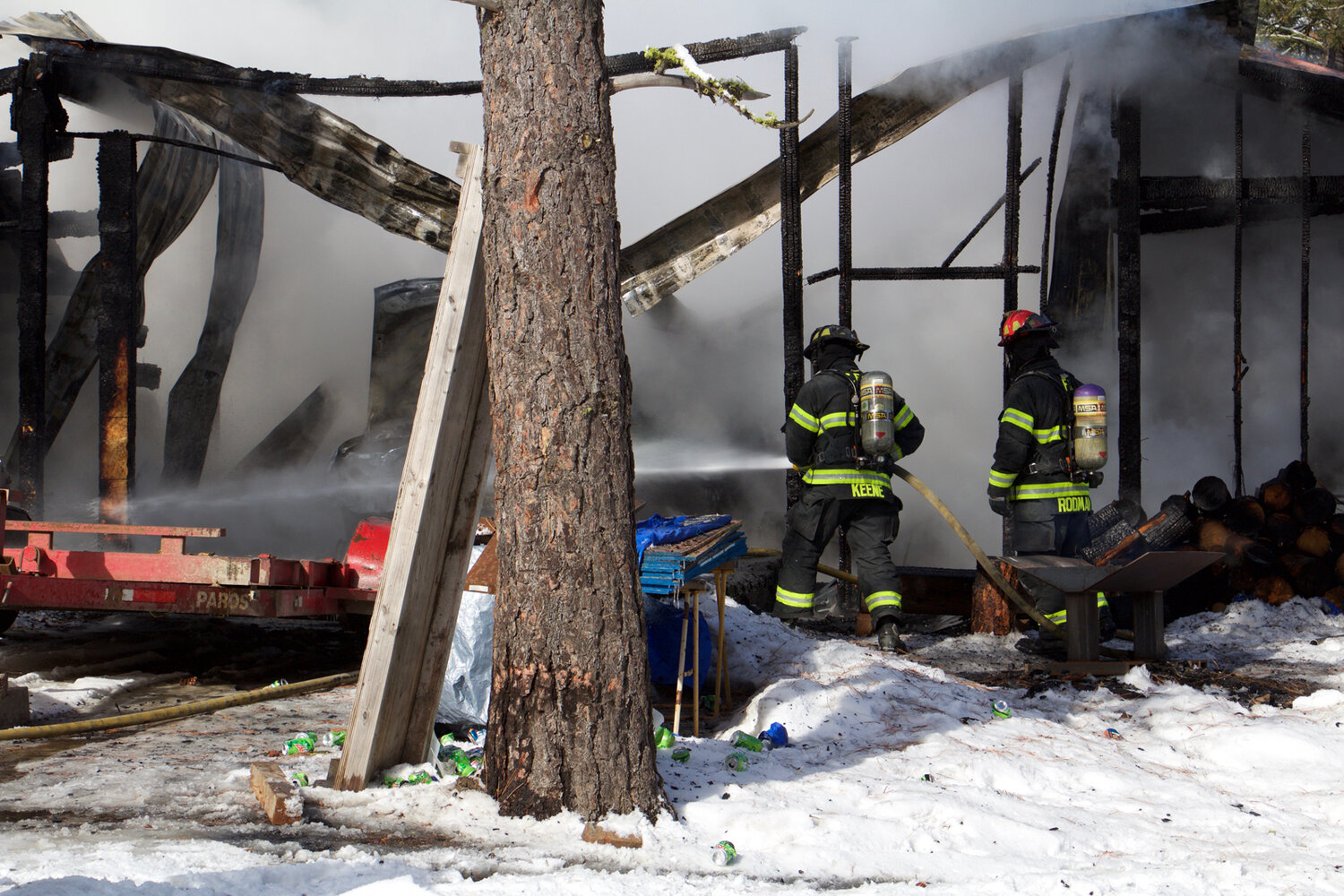Firefighter Keene (left) and Lt. Rodman (right) control fire and hot spots located at the front of a garage in Union Valley, Tuesday, Feb. 20.
