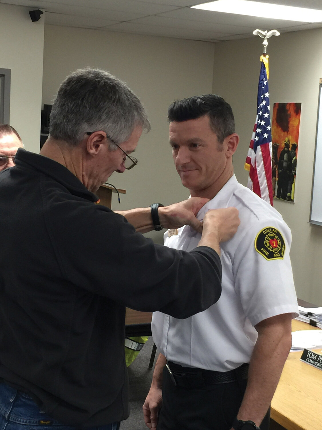 Assistant Chief of Volunteer Services Brandon Asher gets pinned by his father, and Entiat Fire Chief, Mike Asher at the regular commissioner’s meeting, Wednesday, Jan. 10 at Chelan Fire and Rescue (CFR) 7 Station.