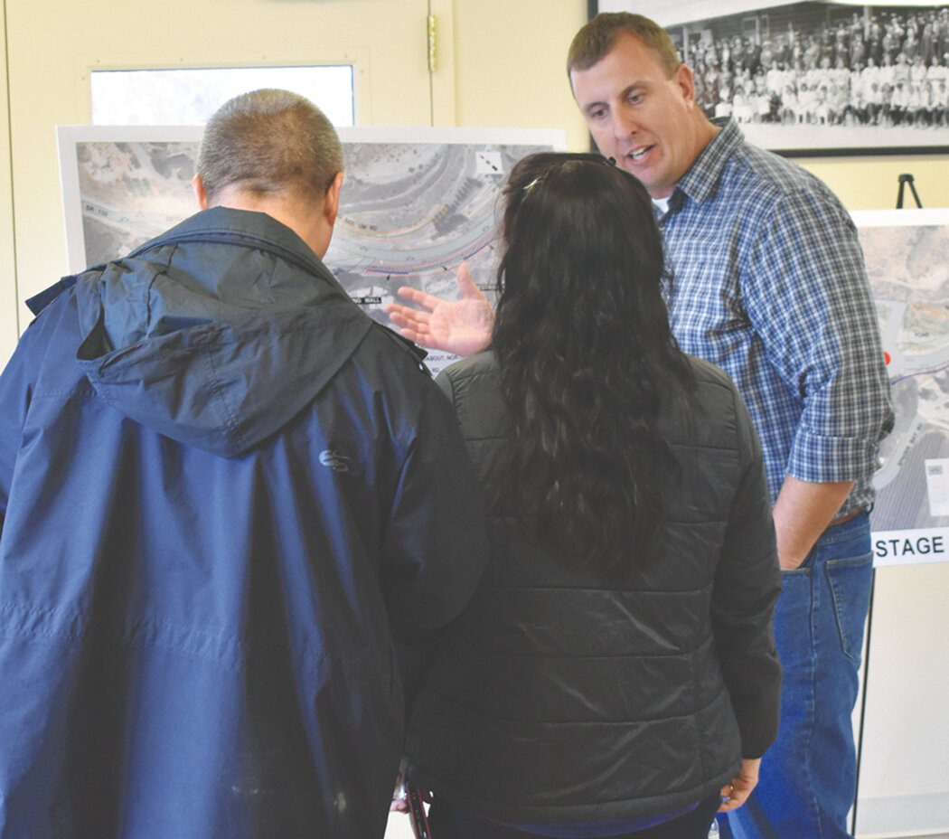 Project Engineer Kevin Waligorski, right, explains the phases of the No See-Um project to a couple at the Manson open house.