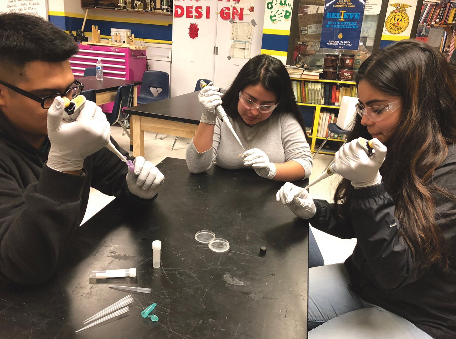 Brewster FFA students Miguel Fernandez, Citaly Pamatz, and Alexia Hurtado wield micro pipettes to work on a gene transformation lab project.