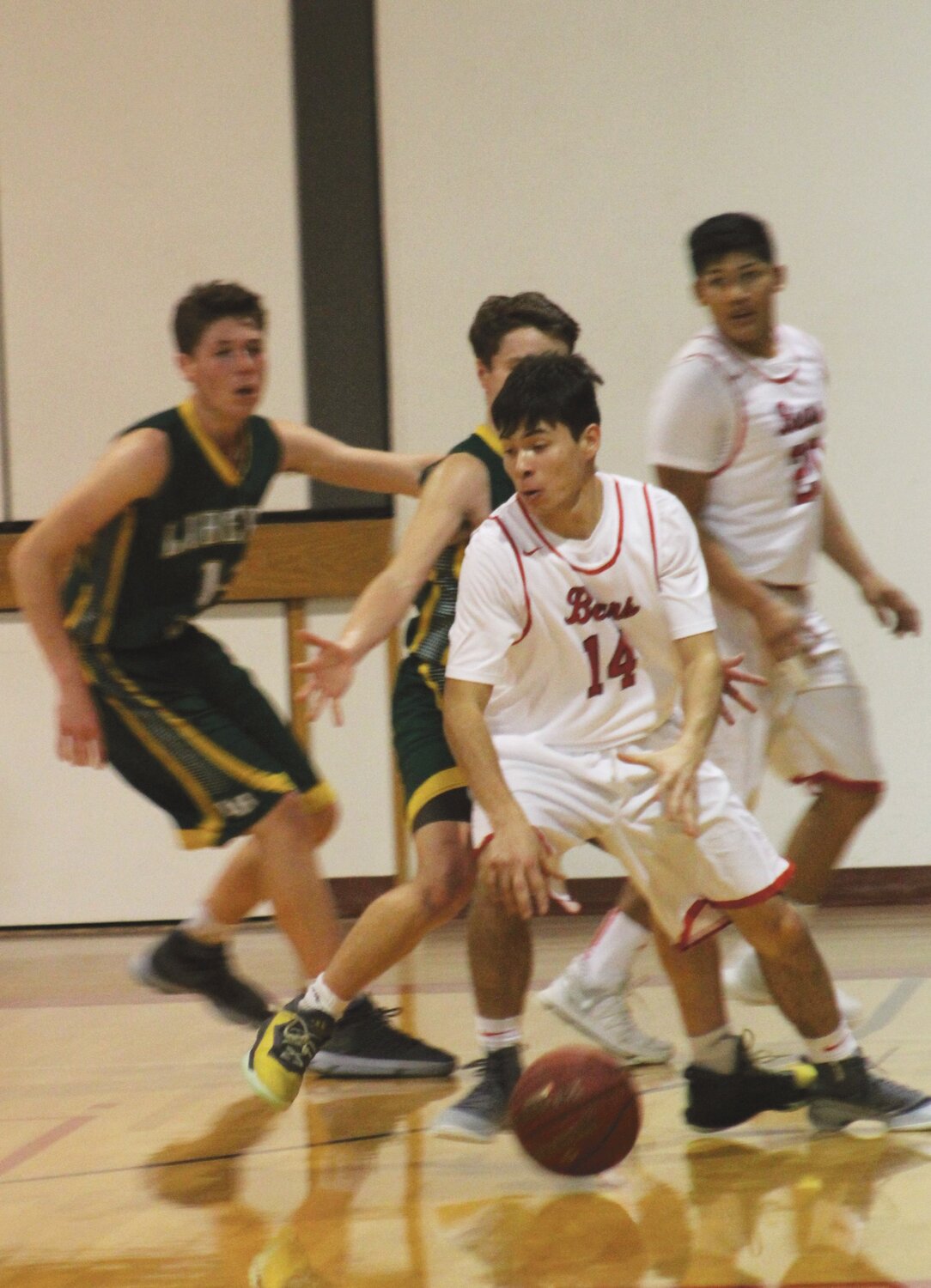 Bears junior guard Ernie Nanamkin (14) looks for an opening against a pair of Mountain Lions’ defenders.