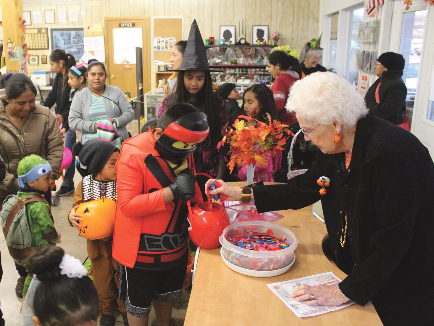 Paula Peckham, right, staffed the candy table and distributed treats to the scores of trick-or-treaters who stopped by the Senior Center on Halloween.