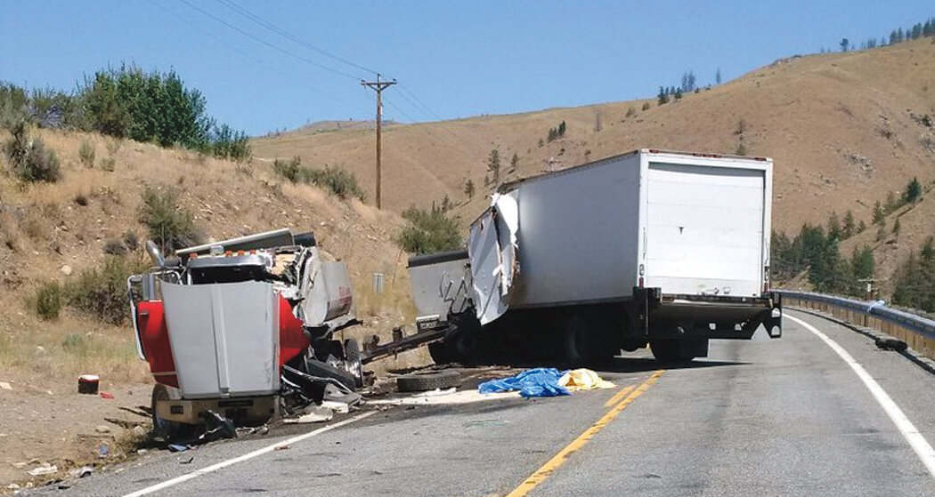 Photo By Mike Maltais
A collision between a southbound dump truck and trailer, left, and a northbound straight truck just before noon, Thursday, July 6, on State Route 153, milepost 8, north of Pateros, claimed the lives of both drivers. An injured passenger in the straight truck was transported to Three Rivers Hospital.