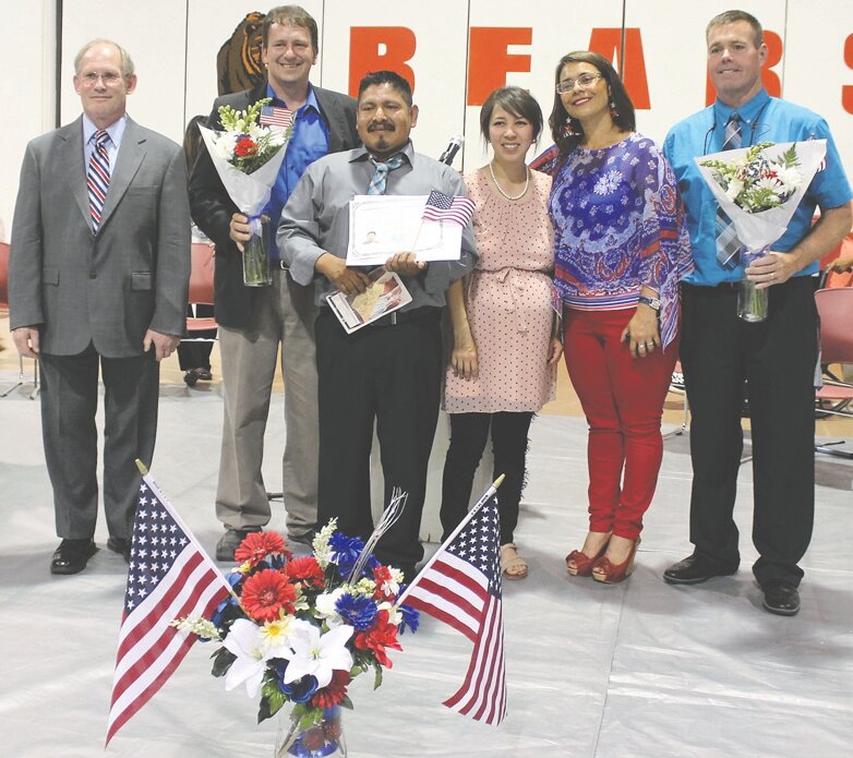 Marcos Apolinas Flores, third from left, shows off his Certificate of Naturalization in the company of USCIS Field Director, Keith Brown, left, keynote speaker, Jon Wyss, citizenship class teacher, Marlen Guzman, USCIS Citizenship Coordinator, Norma Gallegos, and Brewster School District Superintendent, Eric Driessen.
