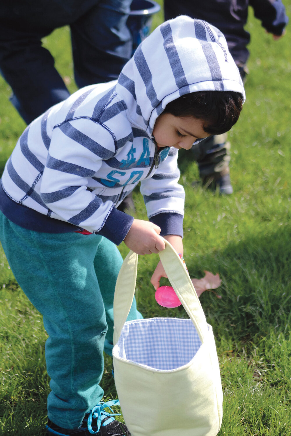 Enrique Sanchez, 3, drops an egg into his bag at the Brewster playfield.
