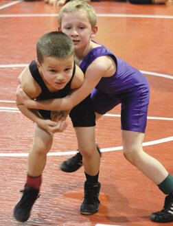 Jack Newman (purple) gets a grip on William Freese of Omak.