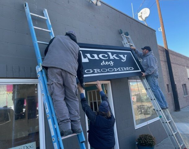 The new sign goes up for Lucky Dog Grooming in Brewster.