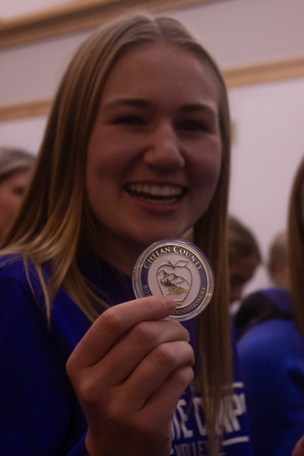 Player Bailey Evans holds up her Chelan County commemorative coin.