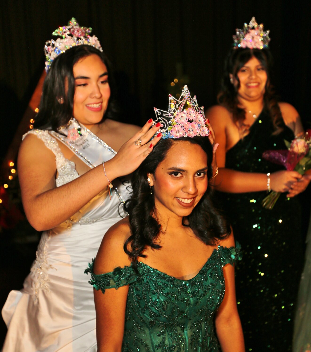 2023 Manson Apple Blossom Queen May Juarez crowns 2024 Princess Natalee Reyna as Princess Liliana Narvaez looks on.