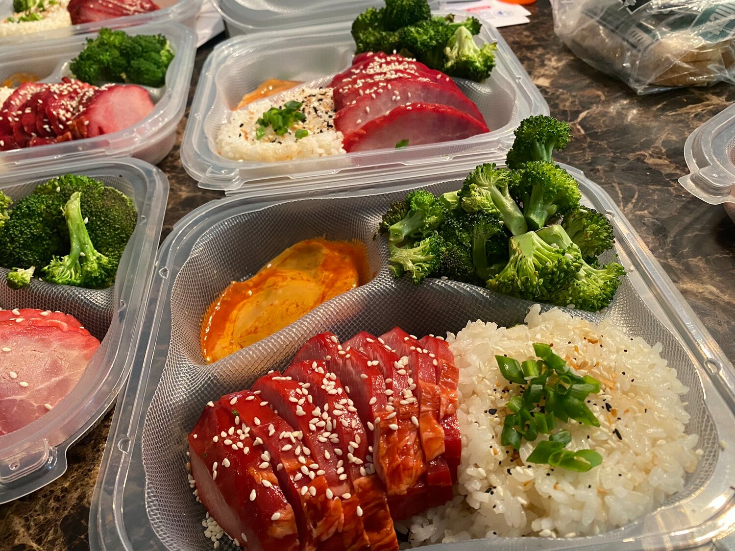 Whatcha Got Cookin! Menus change every week to include diverse options, including Char Siu Pork, roasted broccoli, sticky rice, and spicy mustard. Each meal is $17 per person, and can be delivered for a $5 fee.